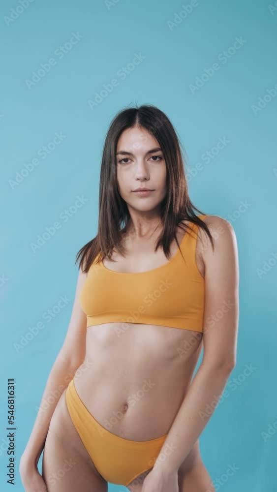 A beautiful model in yellow underwear poses for the camera. Beautiful sexy body. Sexy girl in underwear flirts and shows off her lingerie. Temptation and seduction. blue background. studio. A beautiful model in yellow underwear poses for the camera. Beautiful sexy body. Sexy girl in underwear flirts and shows off her lingerie. Temptation and seduction. blue background. studio.