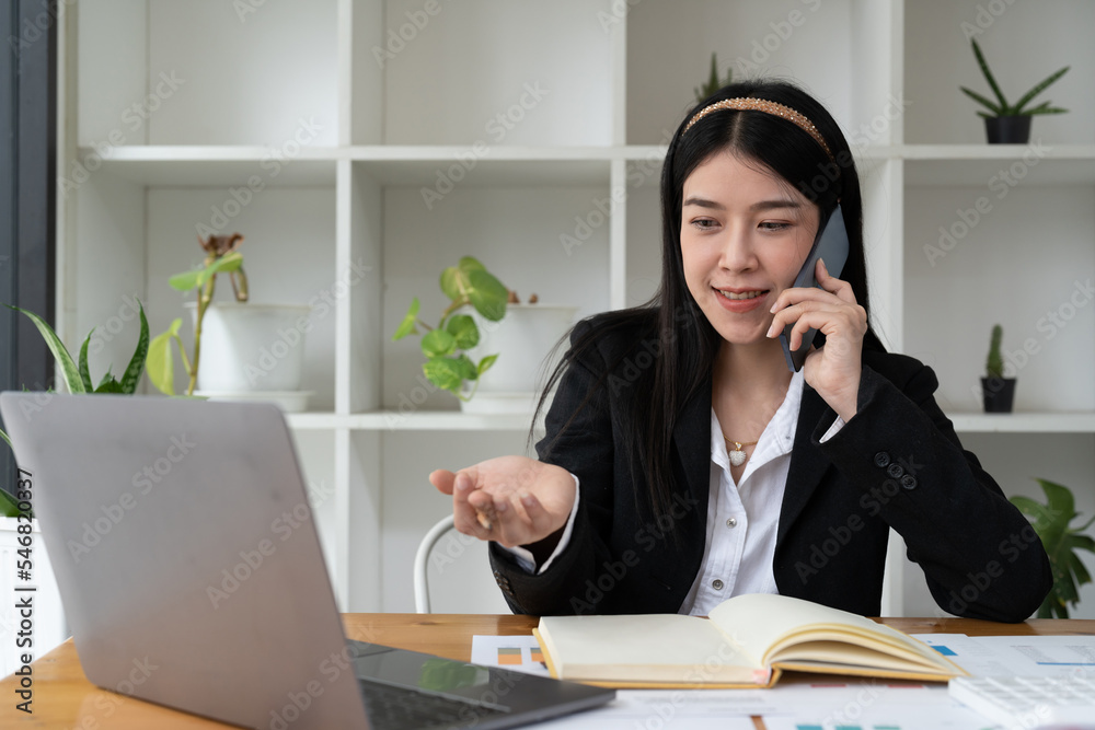 Young Office asian Woman Talking to Someone on her Mobile Phone While Looking Into the Distance with Happy Facial Expression. Young Office asian Woman Talking to Someone on her Mobile Phone While Looking Into the Distance with Happy Facial Expression.