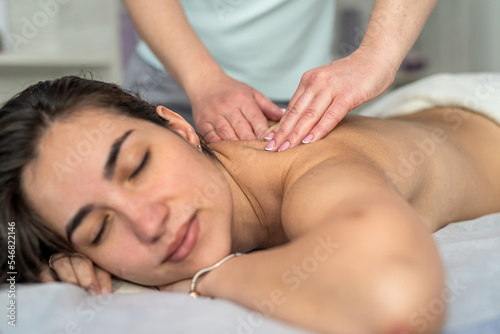 young girl getting relax massage on her back in beauty salon