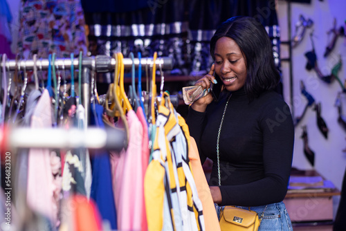 african lady making a phone call in a boutique