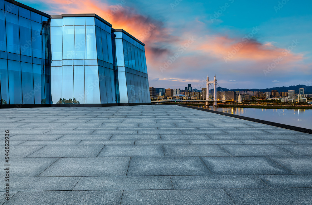 Obraz premium Empty square floor and bridge with urban skyline at sunset in Zhoushan, Zhejiang, China.