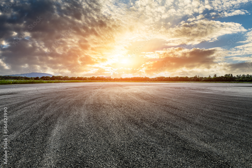Empty asphalt road and green forest with sky clouds at sunset Empty asphalt road and green forest with sky clouds at sunset