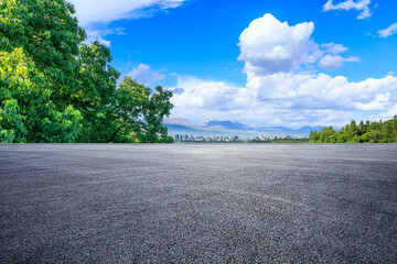 Asphalt road and green tree with city skyline in Hangzhou, China.