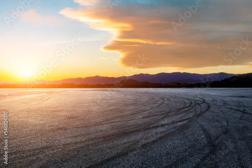 Asphalt road and mountains with beautiful sky clouds at sunset