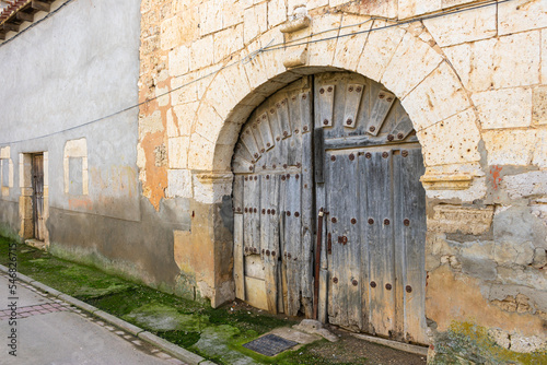 antique wooden door in stone wall © photointruder