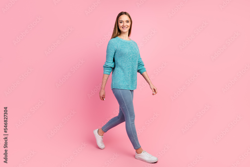 Casual young woman walking with smile isolated on pastel color background Casual young woman walking with smile isolated on pastel color background