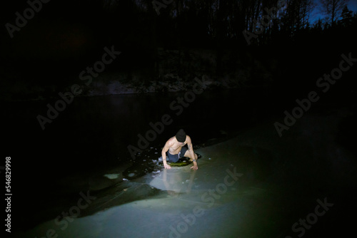 Man swimming in frozen lake