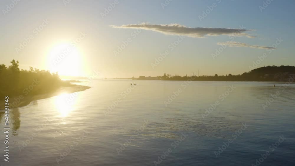 Two kayaks sailing along the Australian coast into the sunset, trees, blue sky Two kayaks sailing along the Australian coast into the sunset, trees, blue sky