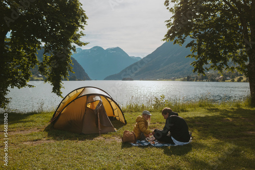 Father and daughter camping by lake