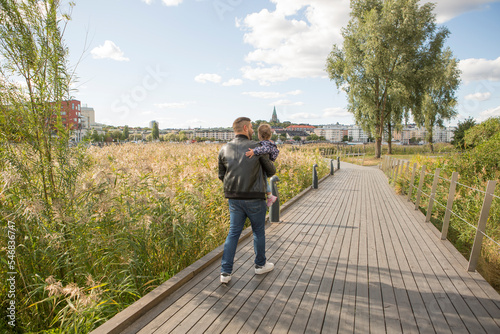 Man carrying his daughter in park