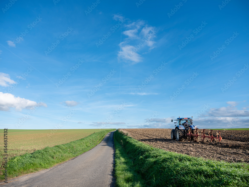 tractor and plow on field in rural belgian countryside near brussels