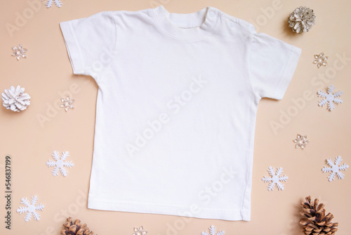 Baby t-shirt mockup for logo, text or design on pink background with winter decorations top view © Alina