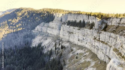 View of the rock face of Creux du Van in the canton of Neuchâtel and Vaud in Switzerland. Forest, fir trees and rocks. A sight of Switzerland photo