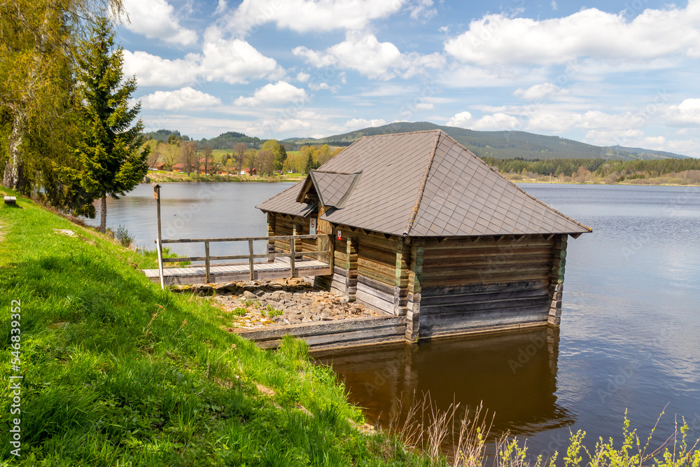 sluice house on the dam of the pond - wooden house on the water by the shore of the Olsina pond, Czech republic