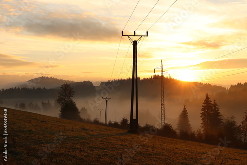 sunrise in the mountains with power lines