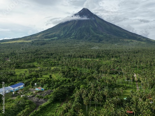 Scenic shot of the Mayon volacano in the Philippines with lush greenery on it and on its bottom photo