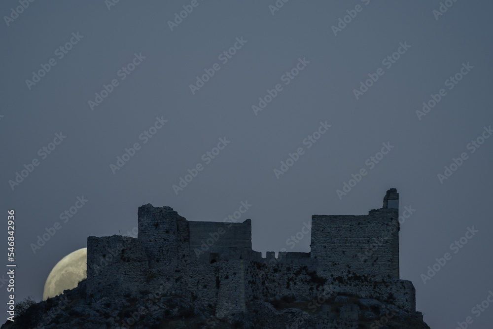Obraz premium Hunting the full moon as it rises behind the ruins of the castle of Moclin, in the province of Granada, Spain.