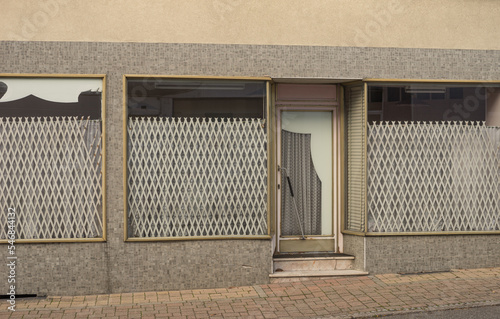 Facade of an old shop from 1970 with gold-colored windows and door frames