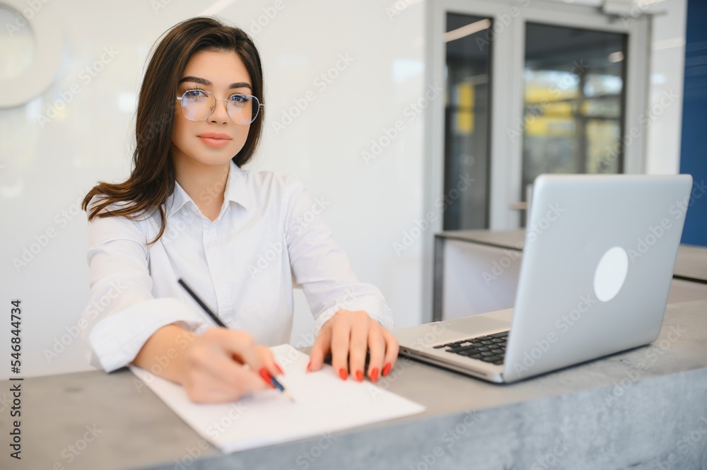 Young female receptionist working in office Young female receptionist working in office