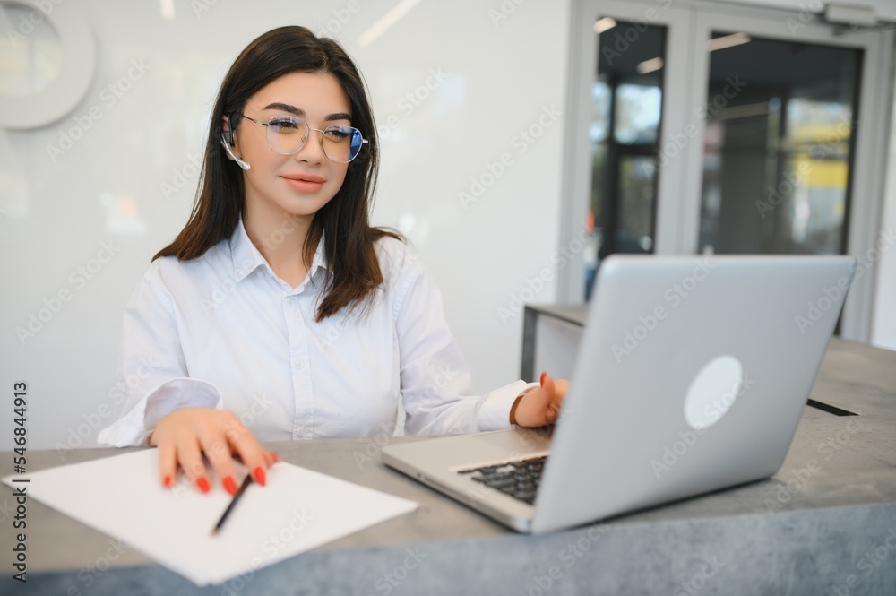 Portrait of receptionist at desk in lobby Portrait of receptionist at desk in lobby
