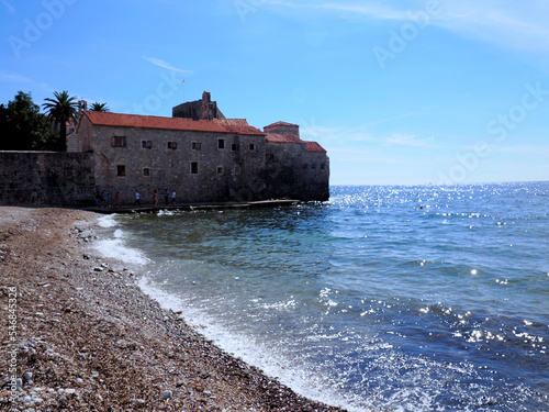 Urokliwe wąskie uliczki i mury obronne historycznego miasta Budvy w Czarnogórze
