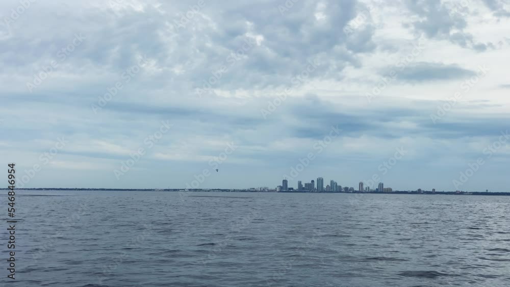 Cloudy Sky Over City Skyline In Distance Across Tampa Bay In Florida, USA. wide Cloudy Sky Over City Skyline In Distance Across Tampa Bay In Florida, USA. wide