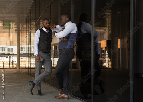 Portrait of two handsome african american businessman partner friends in suit against modern building exterior