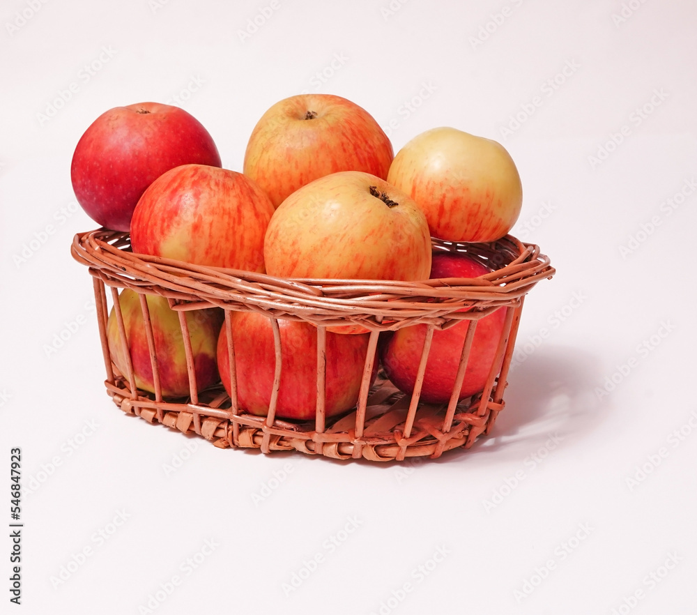 Red ripe apples in a wicker basket on a white background. Red ripe apples in a wicker basket on a white background.