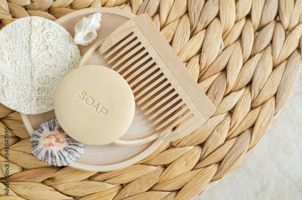 Bar of soap (solid shampoo), loofah bath sponge and wooden hairbrush (comb). Eco friendly toiletries set. Natural beauty treatment, skin care or zero waste concept. Top view, copy space.
