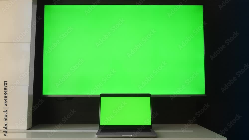 Modern laptop and TV with green screens close up. Modern laptop and TV with green screens close up.