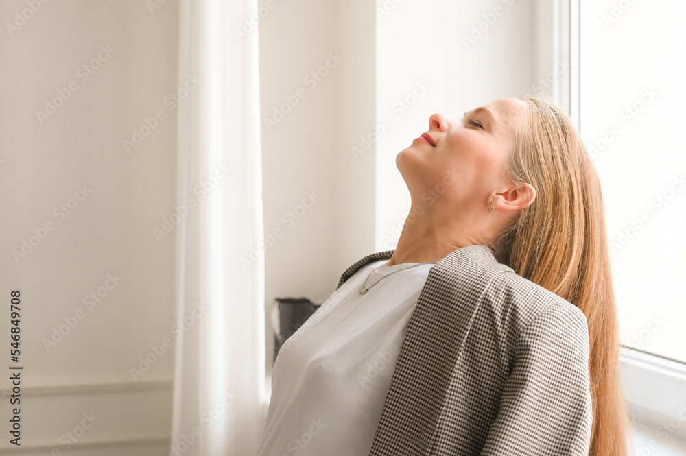 Portrait of enjoying blonde woman indoors. Satisfied caucasian woman with long hair is relaxing. Eyes closed portrait Portrait of enjoying blonde woman indoors. Satisfied caucasian woman with long hair is relaxing. Eyes closed portrait