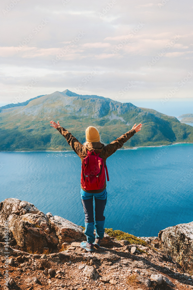 Traveler with backpack in Norway hiking success raised arms Travel adventure active vacations outdoor healthy lifestyle woman on the top of mountain
