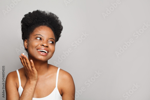 Happy young woman with fresh glowing skin, showing beautiful white smile. Beauty, cosmetology and skin care concept
