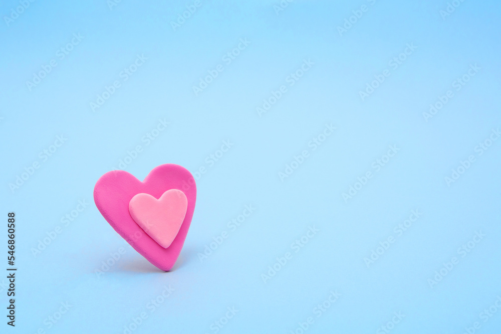 Expression of love, Valentine's Day. Soft pink hearts made of vivid air plasticine, a colorful air mass for children's art on pastel buel background.