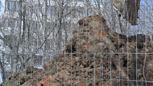 excavator digs a hole and loads the earth with a bucket, close-up