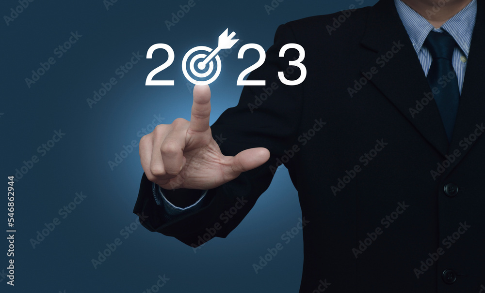 Obraz premium Businessman pressing 2023 letter with goal icon over light blue wall, Business happy new year 2023 success concept