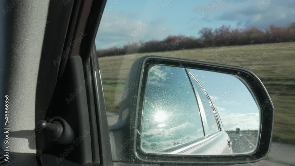 reflection of the road and the car in the rear-view mirror. a trip by car. hitchhiking. reflection of the road and the car in the rear-view mirror. a trip by car. hitchhiking.