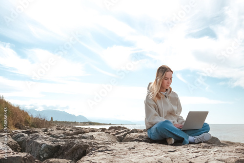 Remote work.Girl freelancer works remotely on the sea shore. workation, remote work,WFVH,Van Life vibes work from vacation home,work travel,remotely work.Travelling.Work from vacation remotely