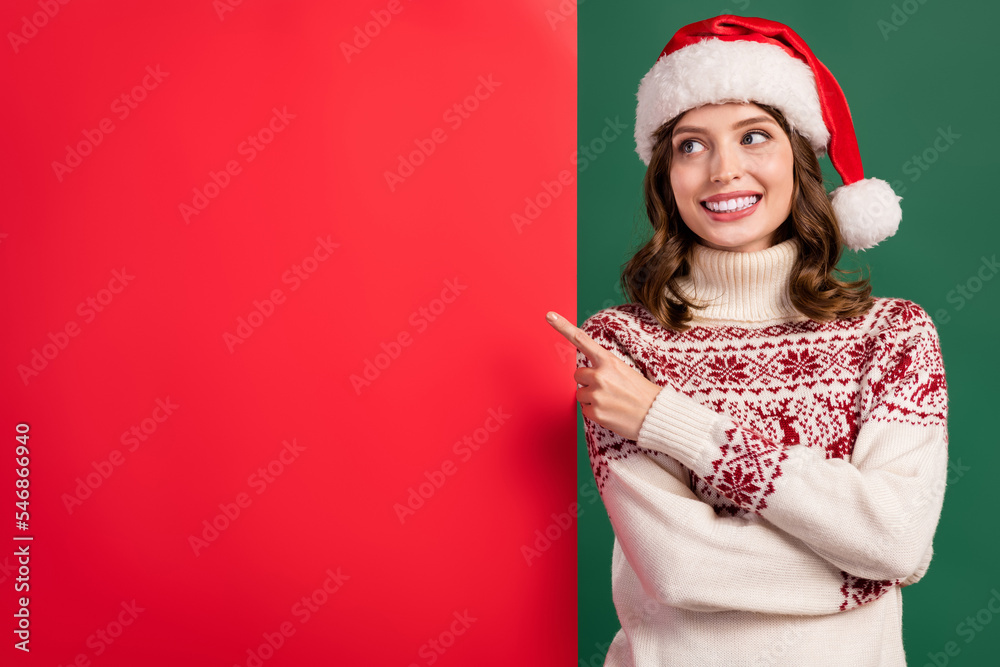 Photo of attractive cheerful girl toothy smile look direct finger empty space x-mas poster isolated on green color background Photo of attractive cheerful girl toothy smile look direct finger empty space x-mas poster isolated on green color background