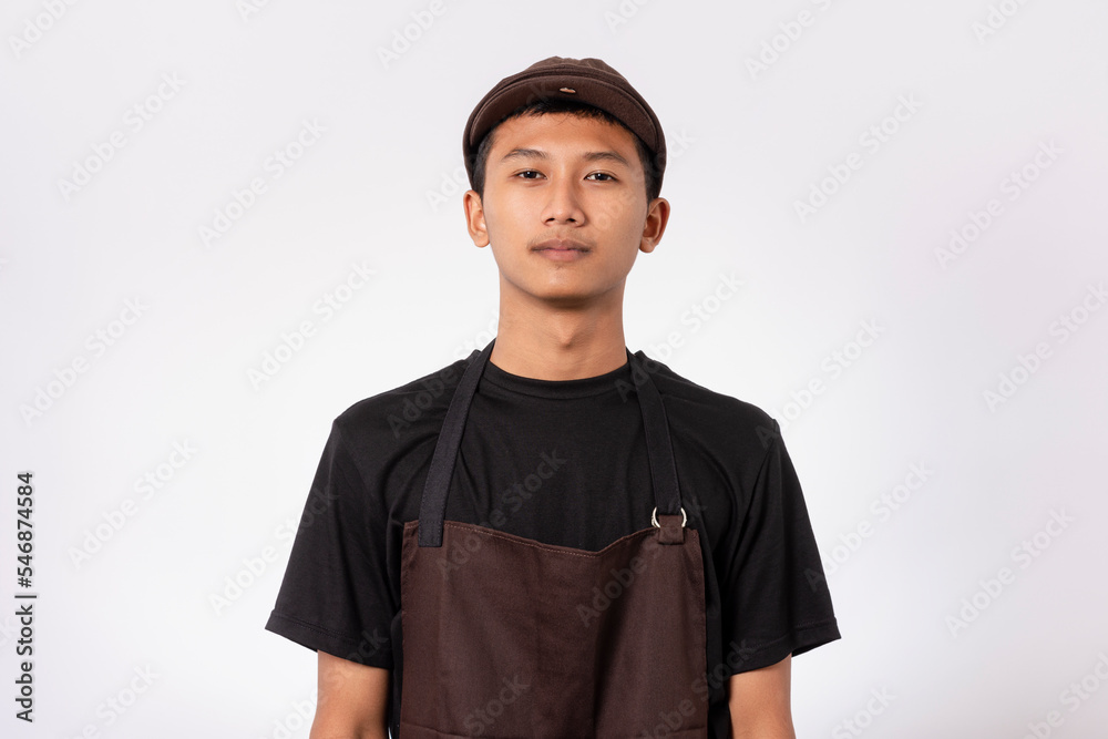 Handsome barista asian man wearing brown apron and black t-shirt isolated over white background standing with crossed arms smiling confident looking at camera Handsome barista asian man wearing brown apron and black t-shirt isolated over white background standing with crossed arms smiling confident looking at camera