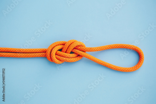 Eight knot on a rope on a blue background. Copy space