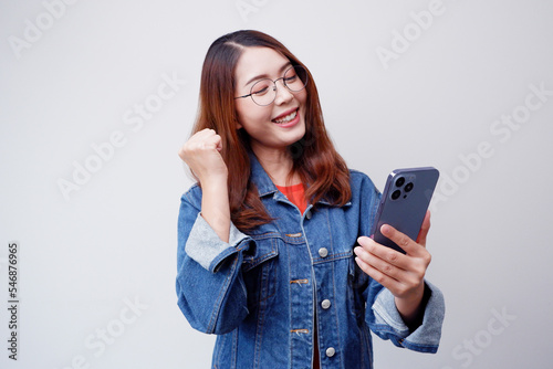 Smiling woman holding a smartphone online shopping.