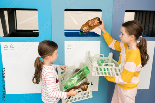 Kids sorting plastic by polymer type and  taking out plastic trash in recycling centre. Sustainble lifestyle concept. National recycling week.