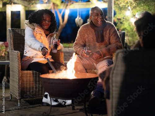 Man and woman sitting by fire pit on patio