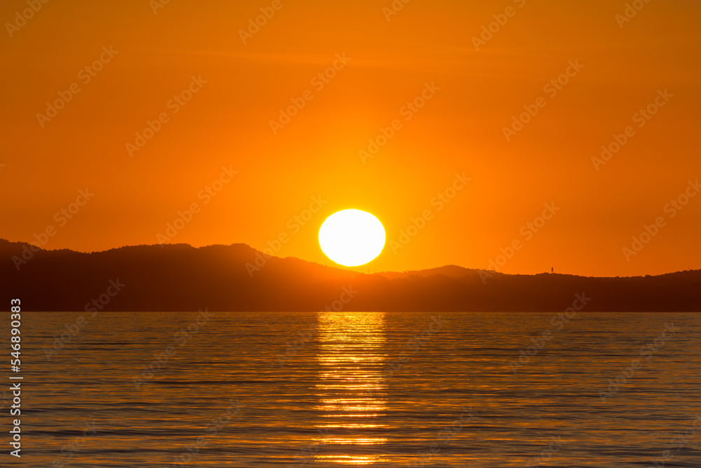 Scenic view of sun globe reflected to Mediterranean sea at golden sunset in south of France