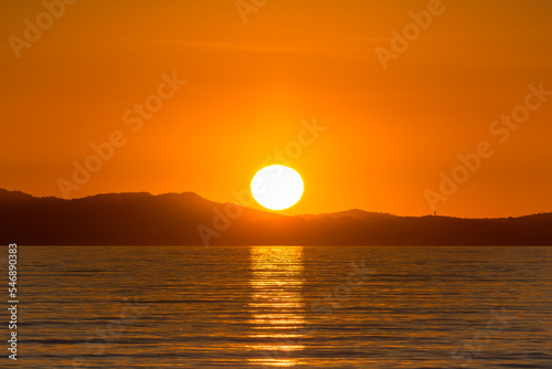 Scenic view of sun globe reflected to Mediterranean sea at golden sunset in south of France