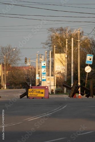 Vertical shot of asphalt street blocked by metal structures in a city photo