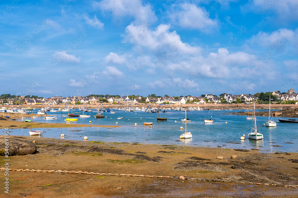 Scenic view of small harbor in Brittany, France at low sea tide against dramatic sky