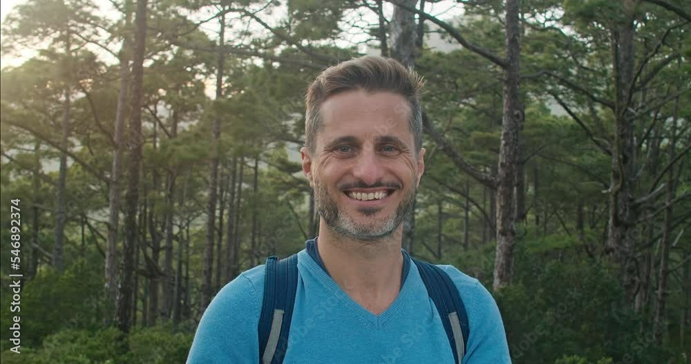 Cheerful male traveler in coniferous forest
