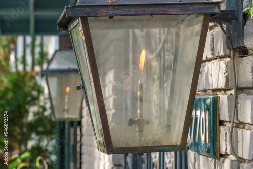 Closeup of Lit Vintage Gas Lamp, with Very Dirty Glass, at the Front of an Historic Home in New Orleans, Louisiana, USA